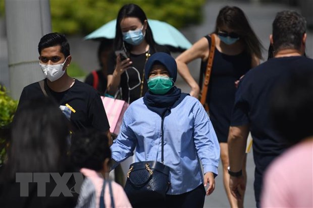 Người dân đeo khẩu trang để phòng tránh lây nhiễm virus corona chủng mới tại Singapore ngày 4/2/2020. (Ảnh: AFP/TTXVN)