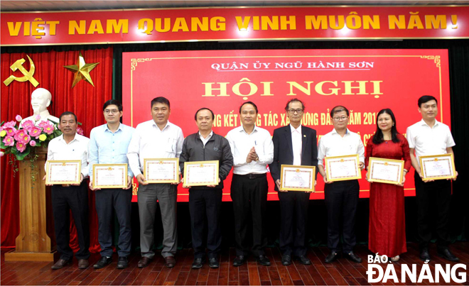 Bí thư Quận ủy Ngũ Hành Sơn Nguyễn Đình Vĩnh (giữa) tặng Giấy khen cho các tổ chức cơ sở Đảng hoàn thành xuất sắc nhiệm vụ trong năm 2019. Ảnh: NHƯ Ý 