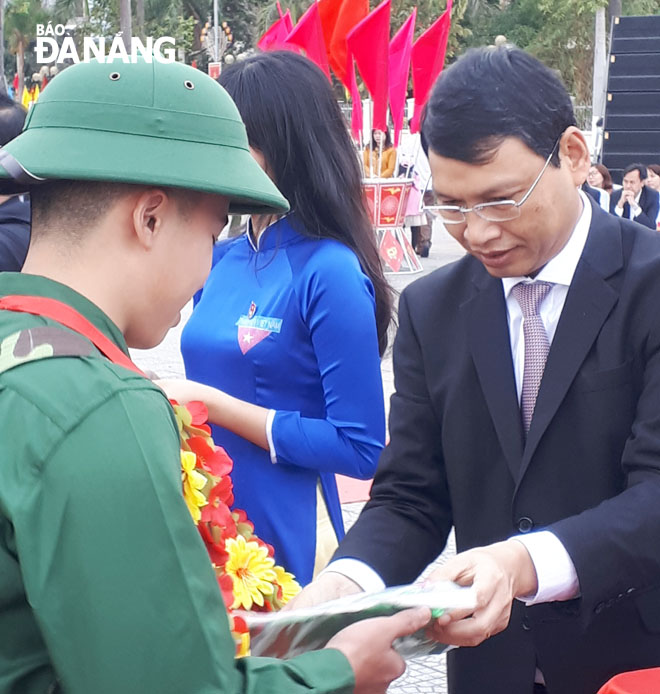 Phó Chủ tịch UBND thành phố Hồ Kỳ Minh tặng hoa chúc mừng tại điểm giao quân quận Liên Chiểu. Ảnh: THANH SƠN
