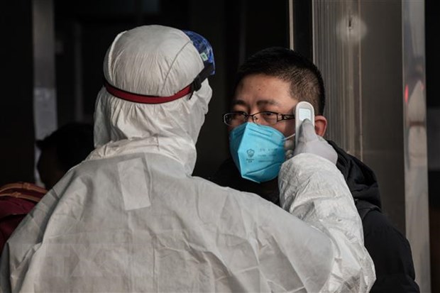 Kiểm tra thân nhiệt một hành khách nhằm ngăn chặn sự lây lan của dịch viêm đường hô hấp cấp do virus corona chủng mới (2019-nCoV) tại nhà ga đường sắt ở Bắc Kinh, Trung Quốc ngày 27/1/2020. (Ảnh: THXTTXVN)