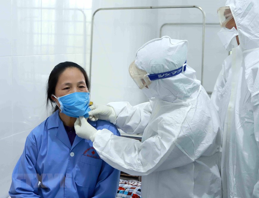 Bác sỹ Đội cơ động phản ứng nhanh của Bệnh viện Bạch Mai (Hà Nội) thăm khám bệnh nhân dương tính với nCoV tại Trung tâm y tế huyện Bình Xuyên (Vĩnh Phúc). (Ảnh: Hoàng Hùng/TTXVN)