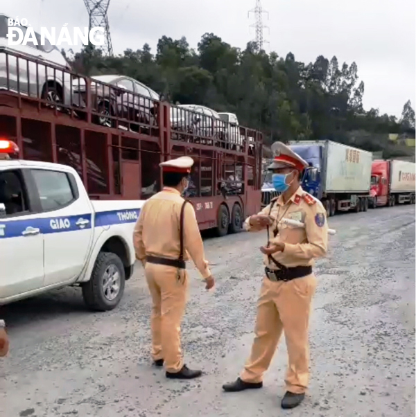 Lực lượng Cảnh sát giao thông Công an thành phố Đà Nẵng có mặt, vận động, giải thích để người dân hiểu và không chặn các xe tải lưu thông. 	                                       Ảnh: ĐẮC MẠNH 