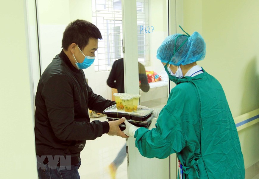 Công dân Trung Quốc nhận những suất ăn của các y bác sỹ mang đến từng phòng. (Ảnh: An Đăng/TTXVN)