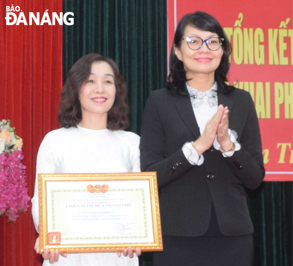 Chủ tịch UBND quận Sơn Trà Trần Thị Thanh Tâm (phải) tuyên dương và trao danh hiệu Chiến sĩ thi đua thành phố cho bà Nguyễn Thị Thanh Huyền.  Ảnh: NAM TRÂN