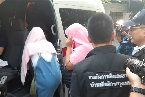 Women hired to be surrogate mothers are ushered into a police van following a raid on a house in Bangkok's Lat Prao district shortly before dawn on February 13.  (Photo: bangkokpost.com)