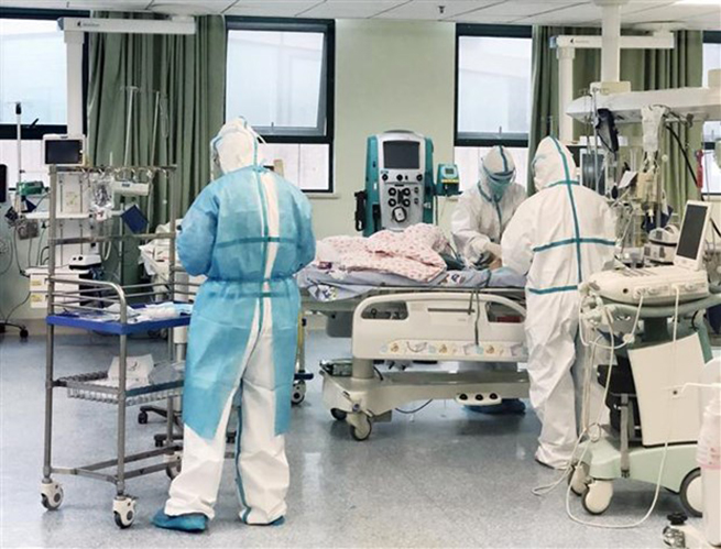Nhân viên y tế Trung Quốc điều trị cho bệnh nhân 14 tháng tuổi bị nhiễm dịch viêm đường hô hấp cấp COVID-19 tại bệnh viện dã chiến ở Vũ Hán, tỉnh Hồ Bắc. (Ảnh: THX/TTXVN)