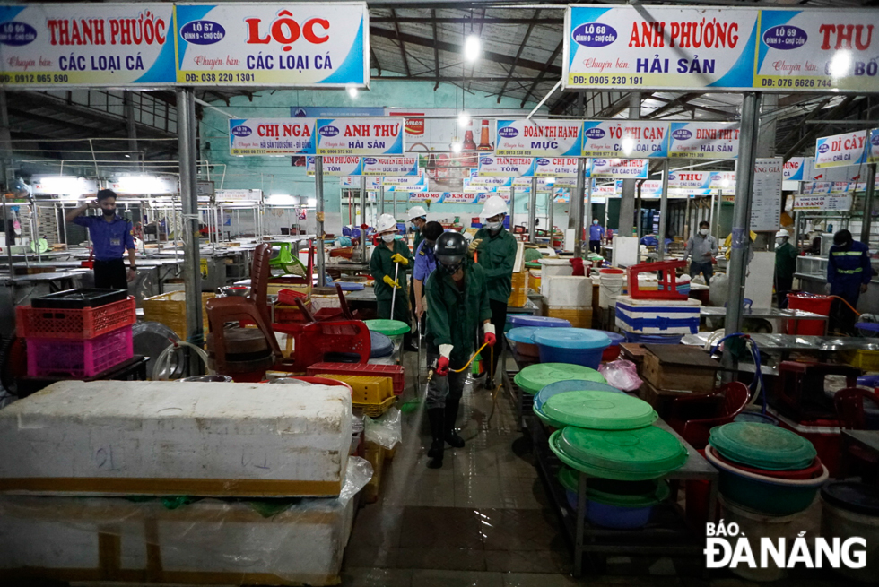 Workers from the Management and Development Company for Da Nang Markets under the management of the municipal Department of Industry and Trade cleaning up the traditional markets