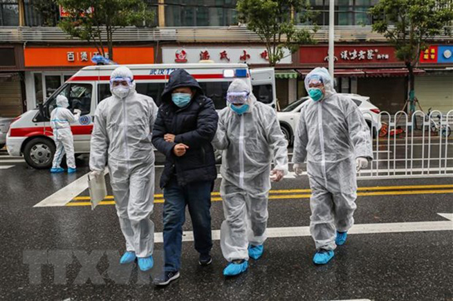 Nhân viên y tế đưa bệnh nhân nhiễm virus corona vào bệnh viện để điều trị tại Hồ Bắc, Trung Quốc. (Ảnh: AFP/TTXVN)