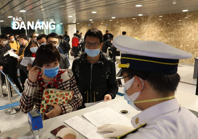 Nhân viên y tế giám sát thân nhiệt cho du khách khi đi và đến Đà Nẵng. Ngày 14-2, lực lượng này giám sát gần 5.000 trường hợp. Ảnh: PHAN CHUNG