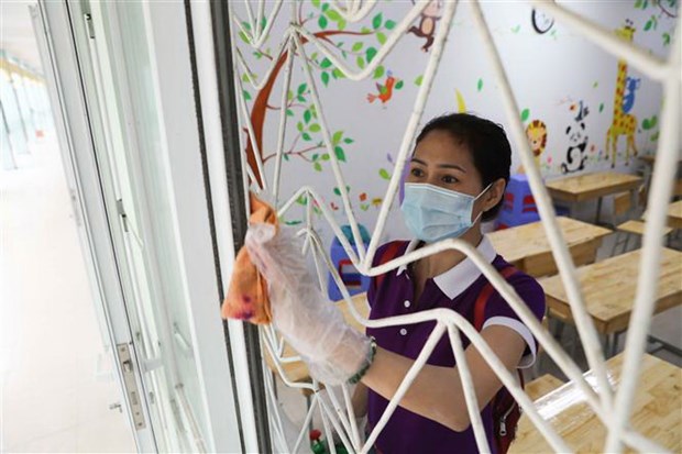 Phun thuốc khử khuẩn kết hợp dọn dẹp, vệ sinh lớp học tại Hà Nội để phòng dịch COVID-19. (Nguồn: TTXVN)