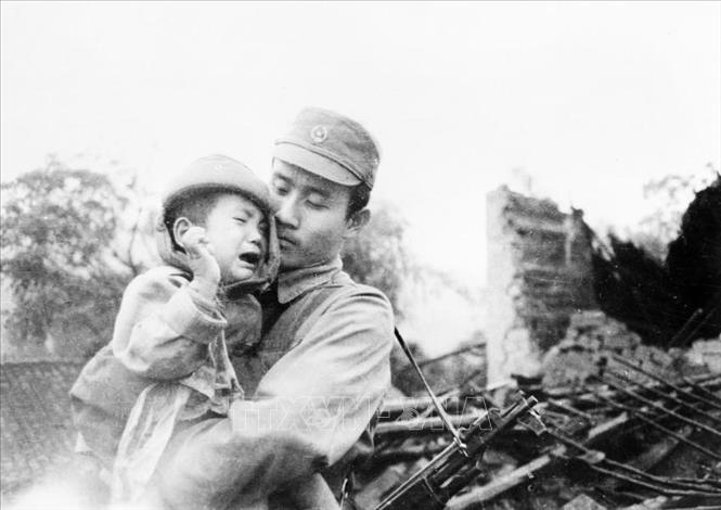Chiến sĩ biên phòng Ngô Duy Nhung cứu sống kịp thời cháu bé này từ trong đống đổ nát. Ảnh: Ngô Đình Phước/TTXVN