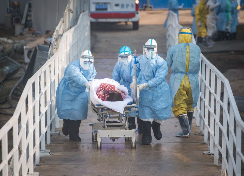 Các nhân viên y tế đưa các bệnh nhân nhiễm covid-19 vào khu vực cách ly tại Bệnh viện Hỏa Thần Sơn ở Vũ Hán, tỉnh Hồ Bắc, Trung Quốc ngày 4/2/2020. Ảnh: Tân Hoa xã