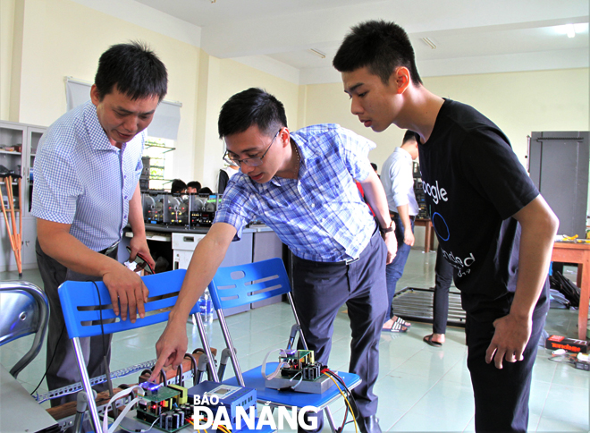 Mr Quan (middle) and his colleagues discussing about their project 