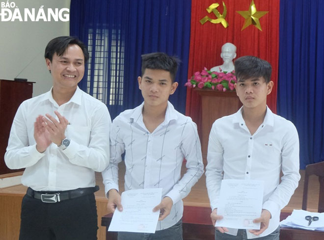 Ông Phan Công Bằng, Bí thư Đảng ủy phường Hòa Hiệp Bắc, tặng quà cho hai thanh niên tự nguyện viết đơn xin nhập ngũ. (Ảnh do địa phương cung cấp)