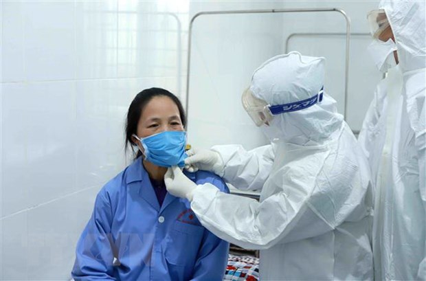 Bác sỹ Đội cơ động Bệnh viện Bạch Mai (Hà Nội) thăm khám cho bệnh nhân dương tính với virus corona chủng mới tại Trung tâm y tế huyện Bình Xuyên, Vĩnh Phúc. (Ảnh: Hoàng Hùng/TTXVN)