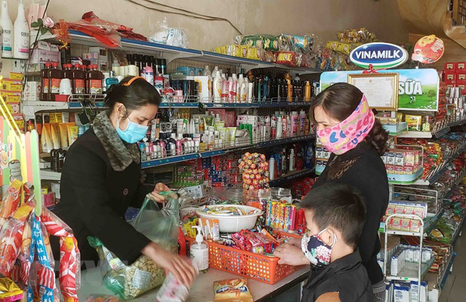 •        Người dân mua hàng tại một cửa hàng tạp hóa xã Sơn Lôi. (Ảnh: Hoàng Hùng/TTXVN)