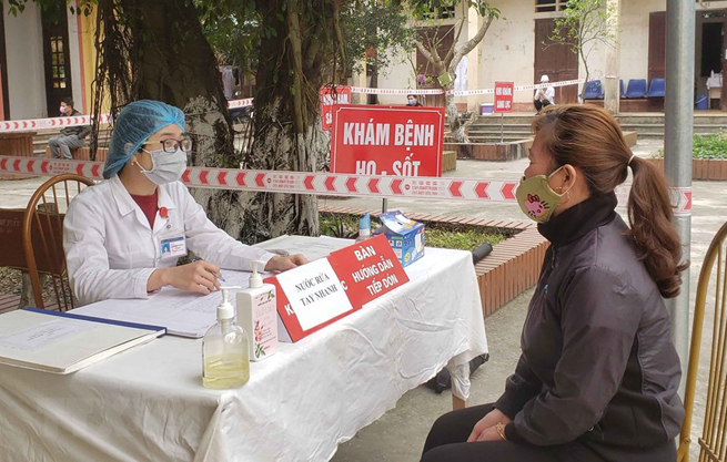 •        Người dân tới khám bệnh tại Trạm y tế xã Sơn Lôi. (Ảnh: Hoàng Hùng/TTXVN)