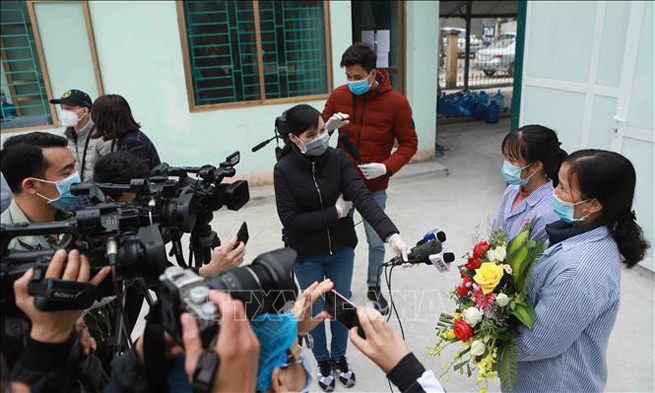 Hai bệnh nhân là bà Nguyễn Thị T. (cầm hoa) và chị Nguyễn Thị Thùy D. trả lời phóng viên.