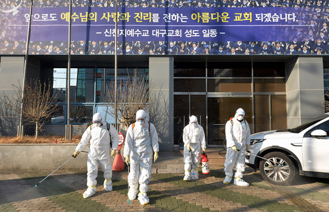 Phun thuốc khử trừng trước một nhà thờ ở thành phố Daegu (Hàn Quốc)		                Ảnh: AP