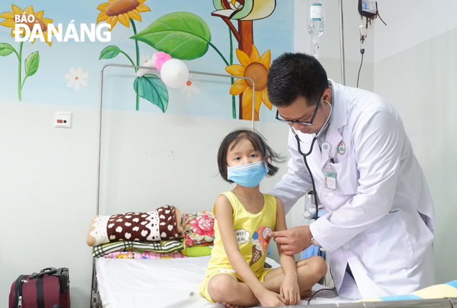 Bác sĩ Đoàn Quốc Bảo, Phó trưởng khoa Nội 3, Bệnh viện Ung bướu Đà Nẵng thăm khám cho một bệnh nhi đang điều trị tại khoa. Ảnh: MAI HIỀN