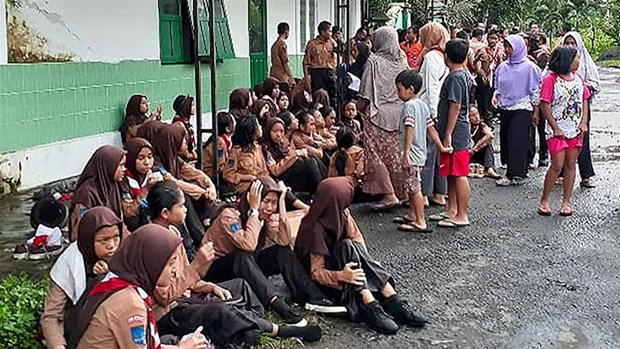 School students huddle together following their rescue in Yogyakarta, after a flash flood killed at least eight students. (Photo: AFP/VNA)