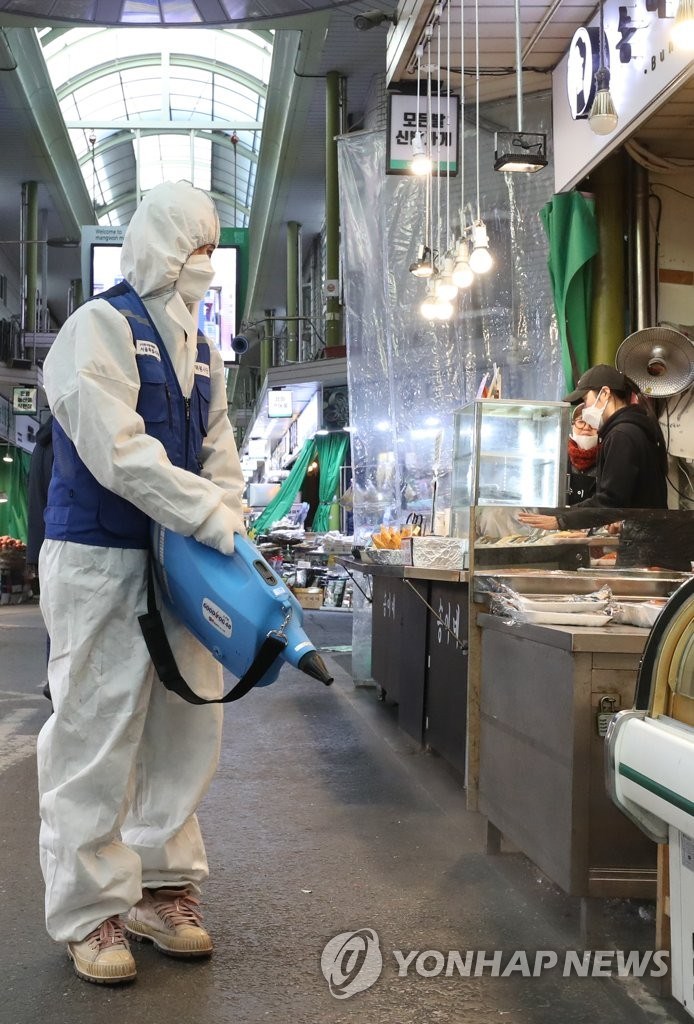 Nhân viên y tế phun thuốc khử khuẩn tại một khu chợ ở Seoul. (Nguồn: Yonhap)