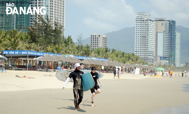 Foreigners going surfing on a local beach