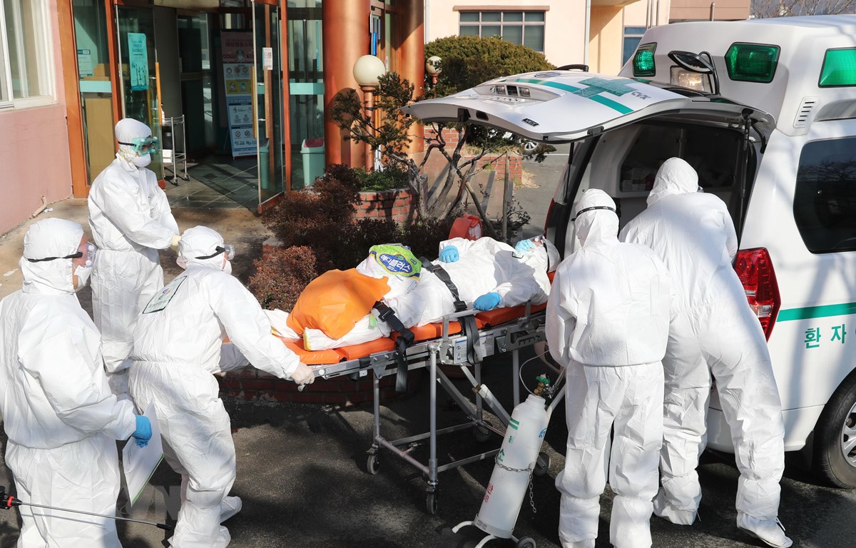 Nhân viên y tế chuyển bệnh nhân nhiễm virus SARS-CoV-2 lên xe cứu thương tại thành phố Daehu, Hàn Quốc. (Ảnh: AFP/TTXVN)