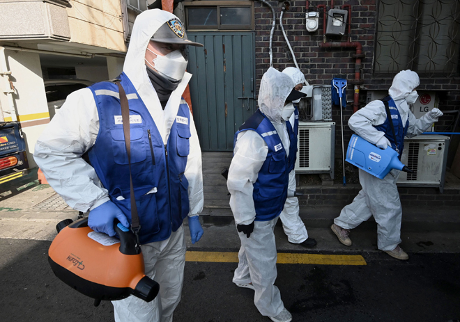 Một khu chợ ở Seoul (Hàn Quốc) được phun thuốc khử trùng vào ngày 24-2.  						                Ảnh: AFP/Getty Images