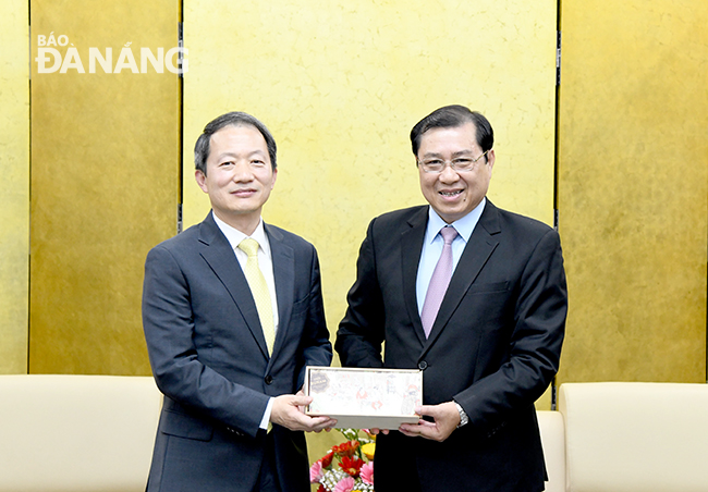 Chủ tịch UBND thành phố Huỳnh Đức Thơ (phải) tặng quà lưu niệm cho Tổng lãnh sự Hàn Quốc tại thành phố Đà Nẵng Ahn Min Sik. Ảnh: ĐẶNG NỞ