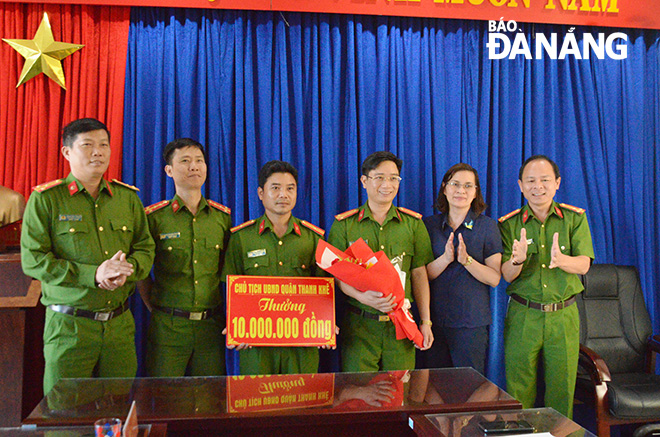Bà Trần Thị Tường Vân, Phó Chủ tịch UBND quận Thanh Khê (thứ 2 từ phải) trao thưởng 10 triệu đồng cho Đội Cảnh sát hình sự. Ảnh: NGỌC PHÚ