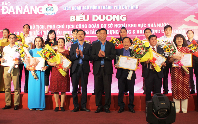 Ông Nguyễn Duy Minh, Chủ tịch Liên đoàn Lao động thành phố (thứ 4, hàng đầu từ trái sang) biểu dương đảng viên tiêu biểu là các chủ tịch, phó chủ tịch Công đoàn cơ sở doanh nghiệp ngoài khu vực Nhà nước.                   Ảnh: TRÀ GIANG