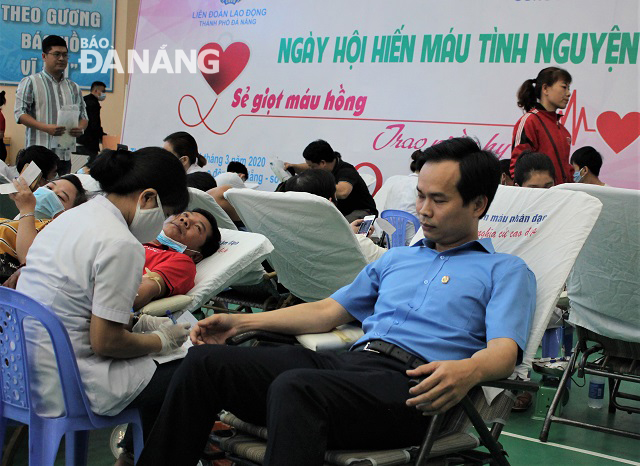 Chủ tịch LĐLĐ thành phố Nguyễn Duy Minh (bìa phải) tham gia hiến máu tại ngày hội. Ảnh: L.P