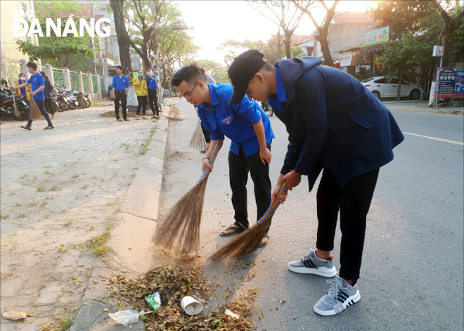 Đoàn viên thanh niên quận Liên Chiểu dọn vệ sinh môi trường trên đường Âu Cơ. 				       Ảnh: TS