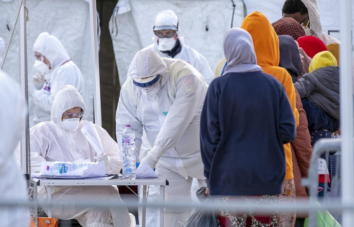 Nhân viên Hội Chữ thập đỏ Italy trong trang phục bảo hộ chống virus SARS-CoV-2 khi tiếp nhận người di cư được giải cứu trên Địa Trung Hải tại khu cảng ở Messina, Sicily ngày 27/2/2020. (Ảnh: AFP/TTXVN)