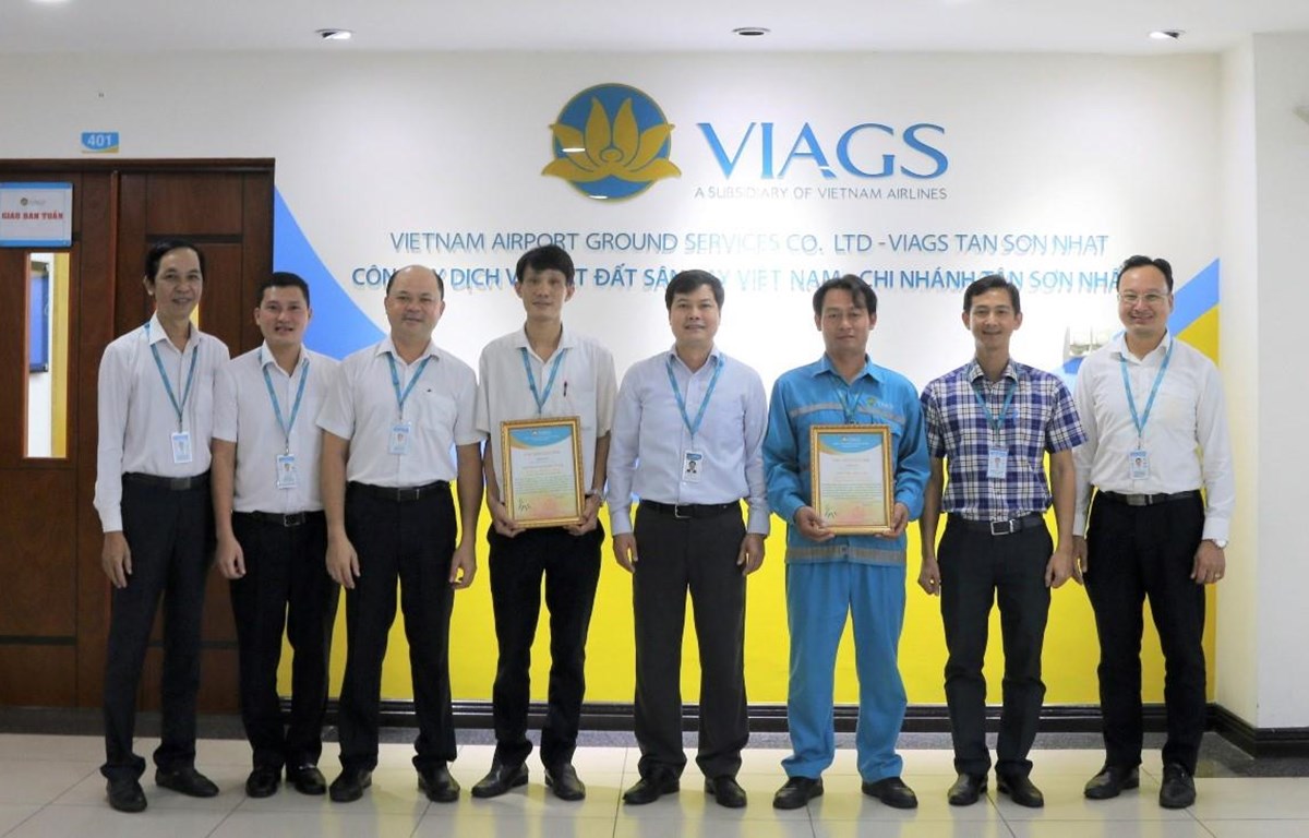 Anh Đường Khánh Tùng (thứ tư từ trái sang) và anh Trần Ngọc Kỳ (thứ ba từ phải sang) nhận thư biểu dương của Ban lãnh đạo Công ty Dịch vụ mặt đất sân bay Việt Nam. (Ảnh: CTV/Vietnam+)