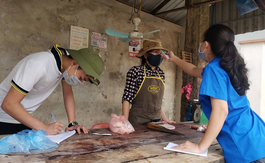 Thanh niên tình nguyện thôn Ái Văn, xã Sơn Lôi theo dõi và đo nhiệt độ hàng ngày cho người dân trong thôn. (Ảnh: Hoàng Hùng/TTXVN)