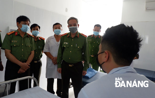 Thiếu tướng Nguyễn Khắc Thủy (hàng trên, thứ 2 từ trái qua) thăm, động viên cán bộ, chiến sĩ công an phường Nại Hiên Đông đang theo dõi sức khỏe tại Bệnh viện 199-Bộ Công an. Ảnh: PHAN CHUNG