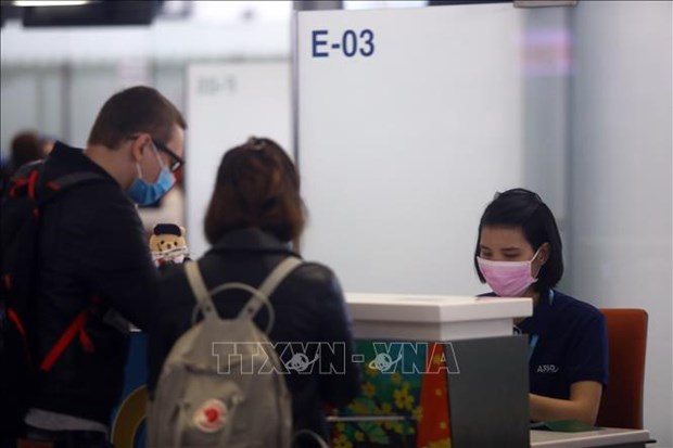 Workers and passengers wear face masks at an airport in Vietnam (Photo: VNA)