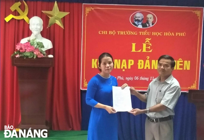 Cô giáo trẻ Nguyễn Thủy Thương (trái) nhận quyết định kết nạp Đảng. Ảnh: LAM PHƯƠNG