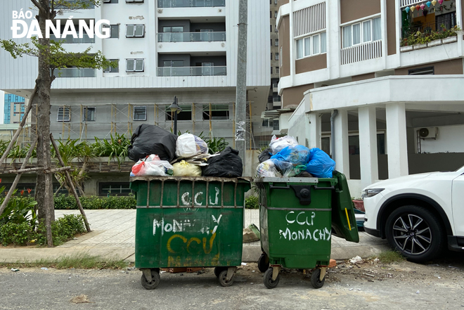 Nhiều thùng rác của khu chung cư, cơ sở kinh doanh tùy tiện đặt trên vỉa hè, lòng đường, gây ô nhiễm và mất mỹ quan đô thị. 						                   Ảnh: T. YẾN