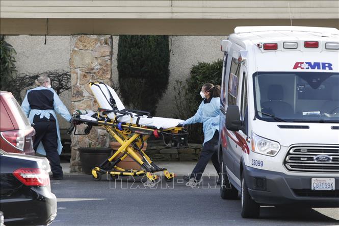 Nhân viên y tế chuẩn bị chuyển bệnh nhân nhiễm Covid-19 lên xe cứu thương tại Kirkland, bang Washington, Mỹ ngày 29-2-2020. Ảnh: AFP/TTXVN