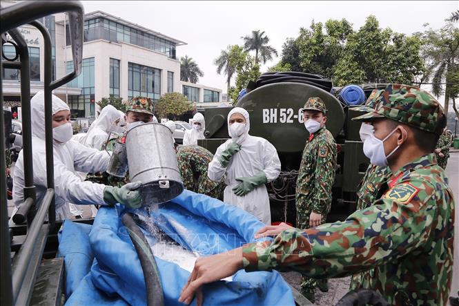 Lực lượng bộ đội hóa học phun hóa chất tiêu tẩy khu vực phố Trúc Bạch, quận Ba Đình, nơi có nhà của bệnh nhân mắc Covid-19. Ảnh: Dương Giang/TTXVN