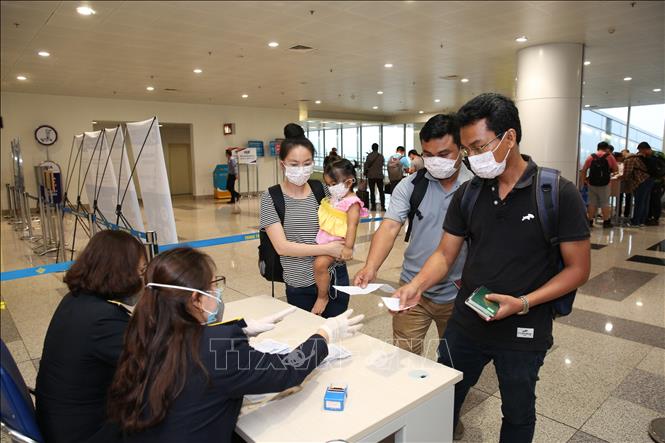 Hành khách làm thủ tục khai báo y tế trước khi nhập cảnh vào Việt Nam tại cửa khẩu Sân bay quốc tế Nội Bài (Hà Nội), chiều 7/3. Ảnh: Dương Giang/TTXVN