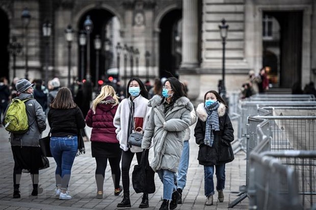 Người dân và du khách đeo khẩu trang phòng tránh lây nhiễm COVID-19 tại Paris, Pháp. (Ảnh: AFP/TTXVN)