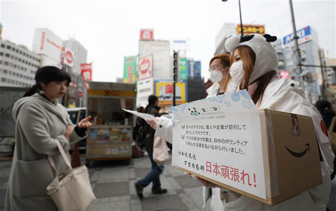 Phát khẩu trang miễn phí để phòng tránh lây nhiễm COVID-19 tại Tokyo, Nhật Bản, ngày 7/3. Ảnh: THX/TTXVN