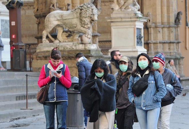 Người dân, du khách mang khẩu trang trên đường phố Florence của Ý ngày 7-3. Ảnh: Reuters