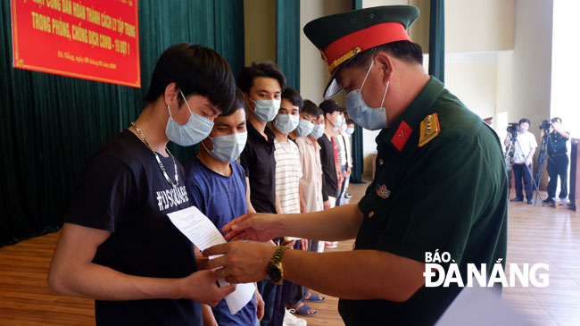 Đại tá Nguyễn Quang Vinh, Phó Chỉ huy trưởng, BCH Quân sự thành phố cấp giấy chứng nhận sức khỏe cho các công dân. Ảnh: PHAN CHUNG