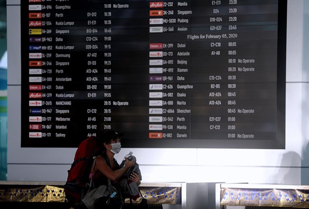 A passenger walks near the flight information board at the departure gate of I Gusti Ngurah Rai International Airport in Bali, Indonesia (Photo: Antara)