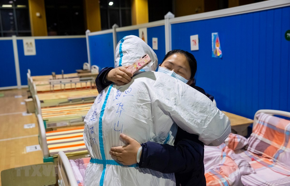 Bệnh nhân nhiễm COVID-19 tạm biệt bác sĩ sau khi được chữa khỏi tại bệnh viện ở Vũ Hán, tỉnh Hồ Bắc, Trung Quốc, ngày 9-3-2020. (Ảnh: THX/TTXVN)